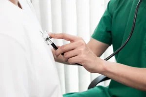 Doctor measures patient's heart rate in office