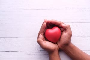 person holds red heart mold in hands