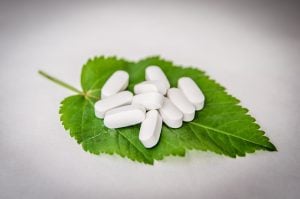 white supplement pills on leaf