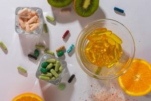 variety of supplements in bowls on table with sliced fruits