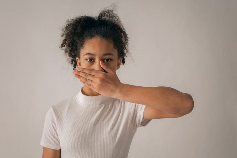 young woman covers mouth with hand