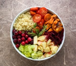 white bowl of vegetables, fruit, and rice
