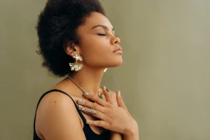 woman in black tank top with hands on chest breathes deeply