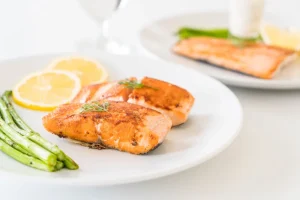 grilled salmon with asparagus and lemon on white plate