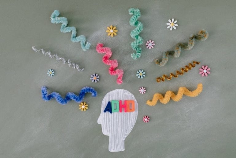 illustrative cut-out of head with 'adhd' and colorful pipe colors representing condition
