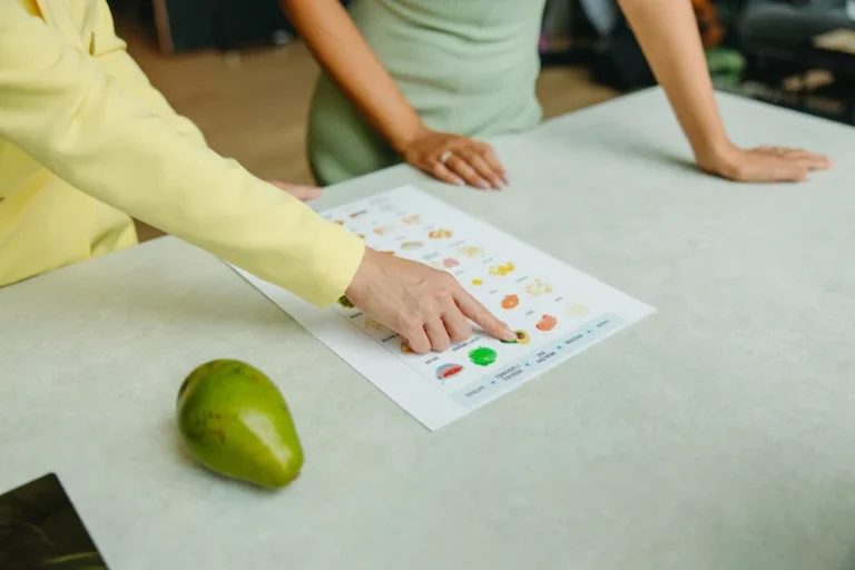 nutritionist points to fruits and vegetables on food chart for patient