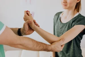 chiropractor holds arm of patient in office