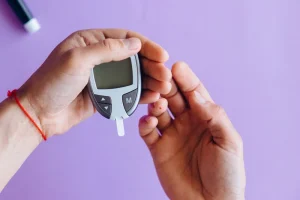 person pricks finger and measures blood sugar with glucose meter