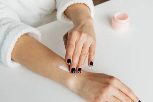 woman applies cream to top of arm